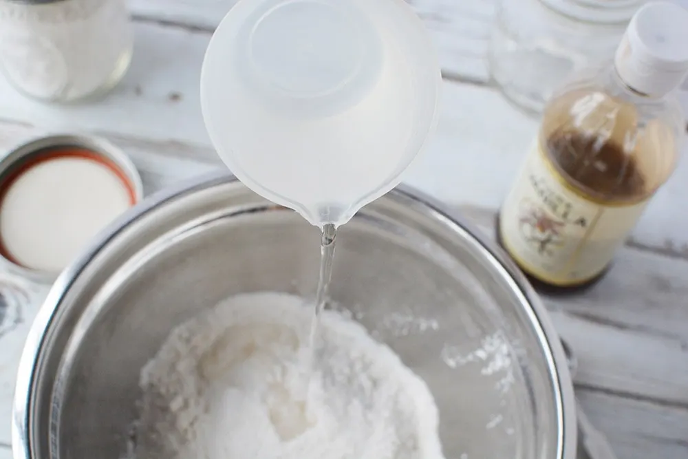 Adding water into pancake mix.