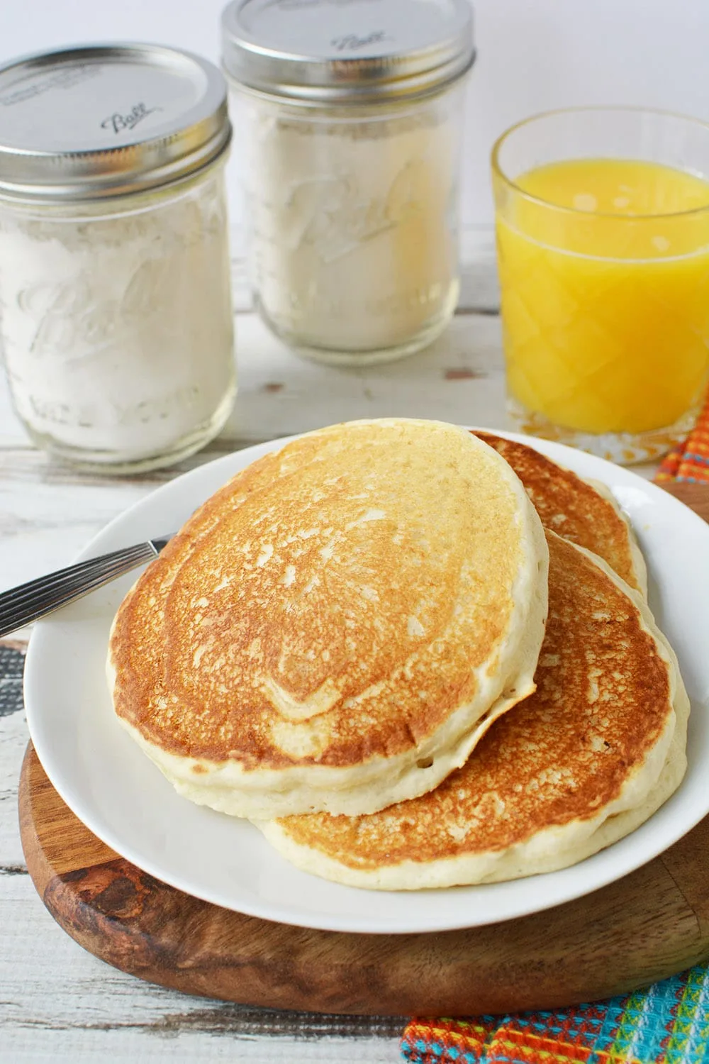 Pancakes on a plate with mix in the background.