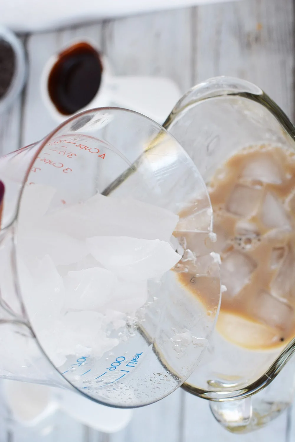 Adding ice to a blender with a coffee mixture. 