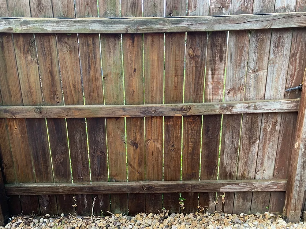 A fence with one side power washed and one before. 