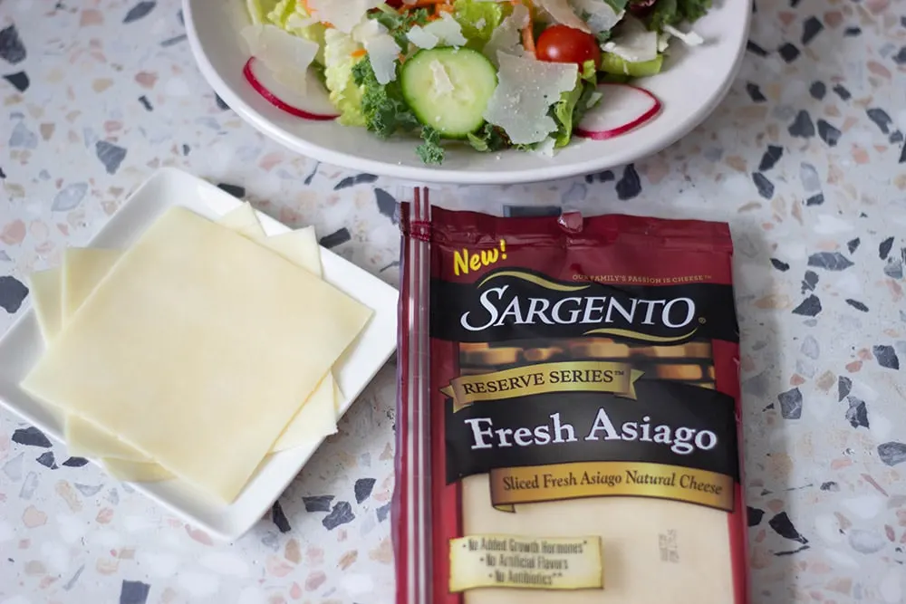 Slices of cheese by a salad.