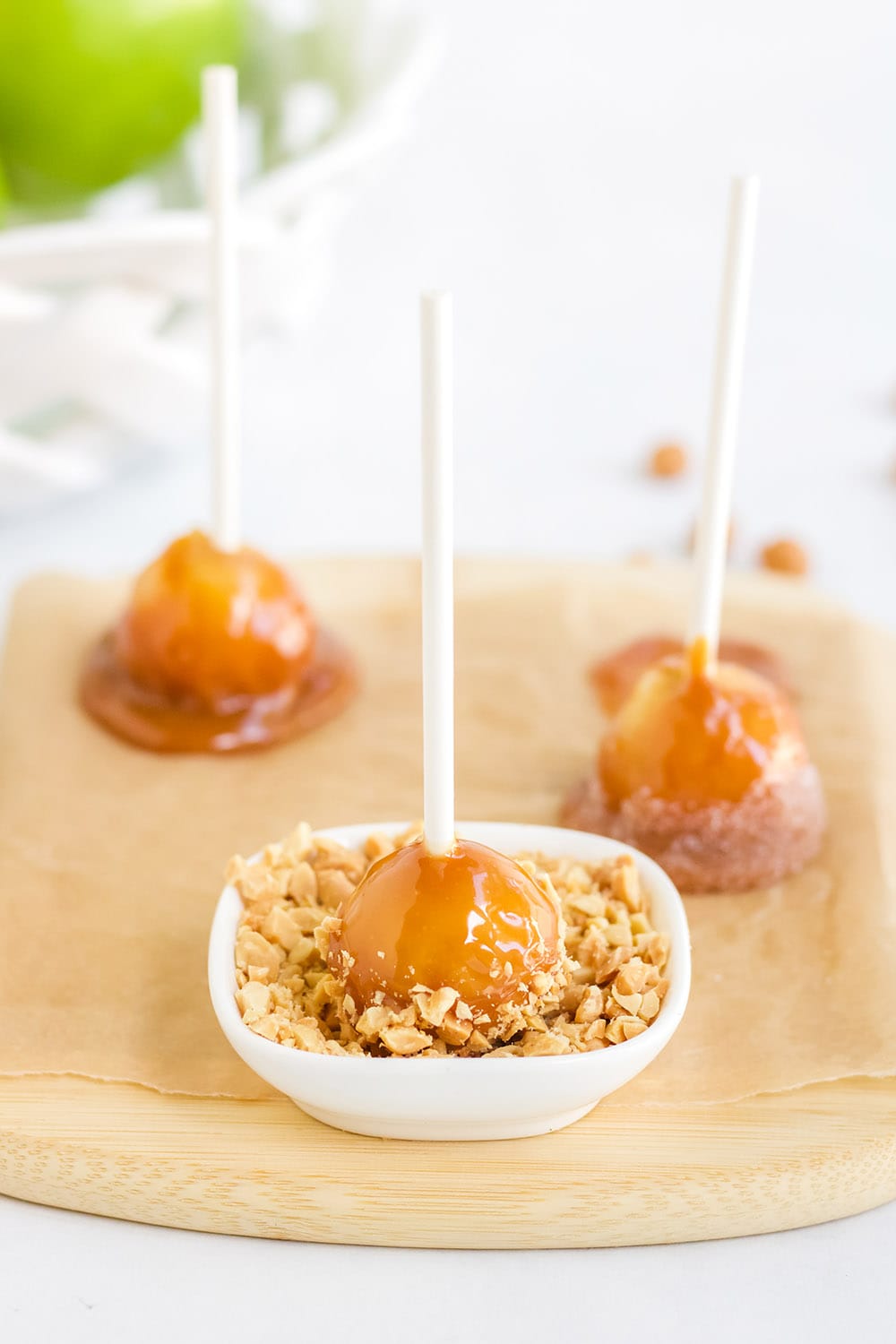 dipping caramel apple into nuts