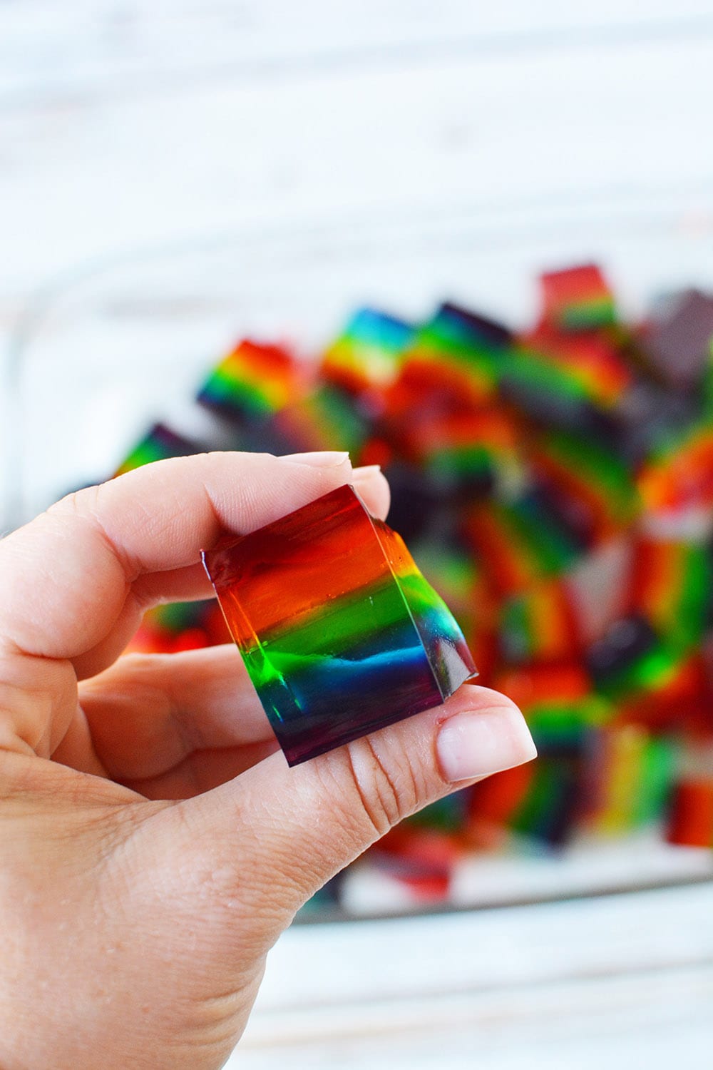 holding a rainbow jello cube