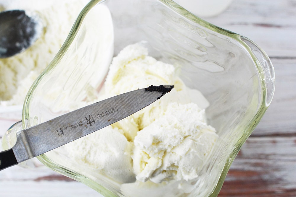 Knife with vanilla beans going into a blender.