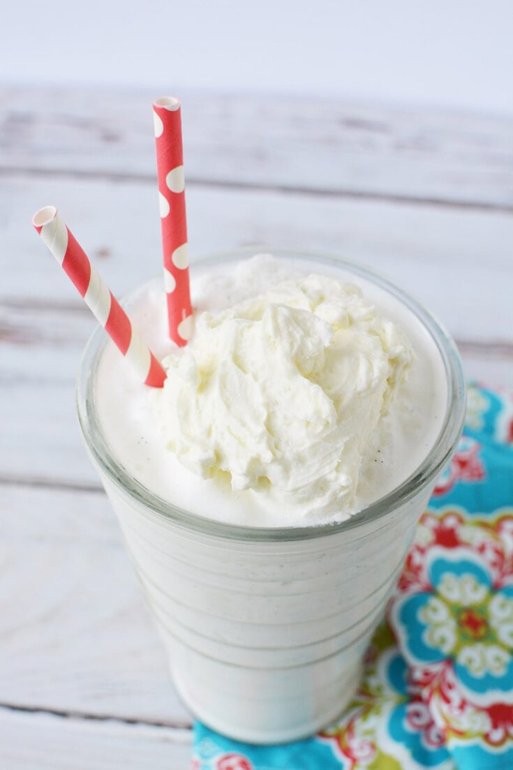 blended vanilla bean frappe in a glass with two red straws