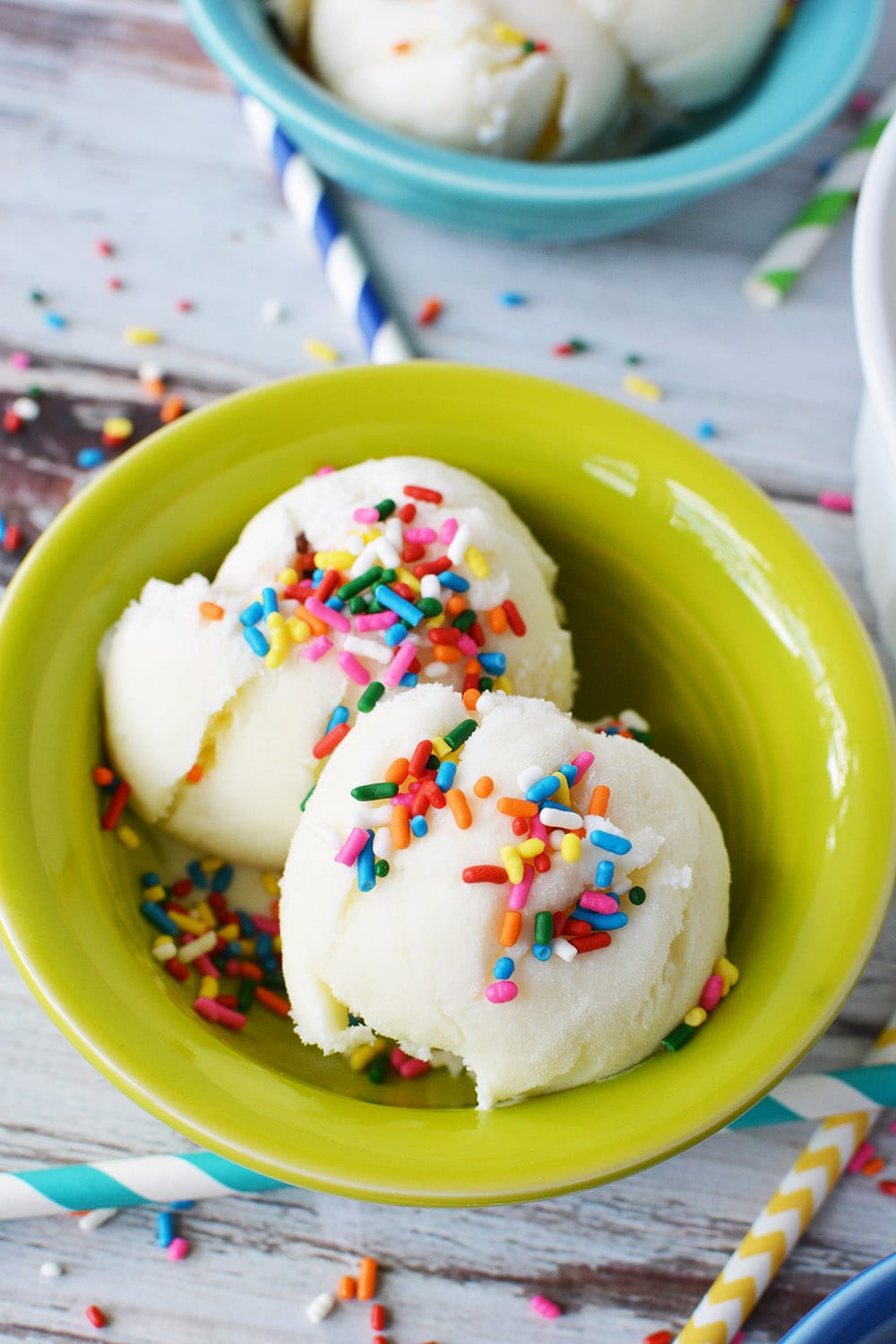 Birthday cake ice cream topped with sprinkles in a green bowl