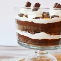 chocolate trifle with layers of pudding, whipped cream, and cake in a bowl