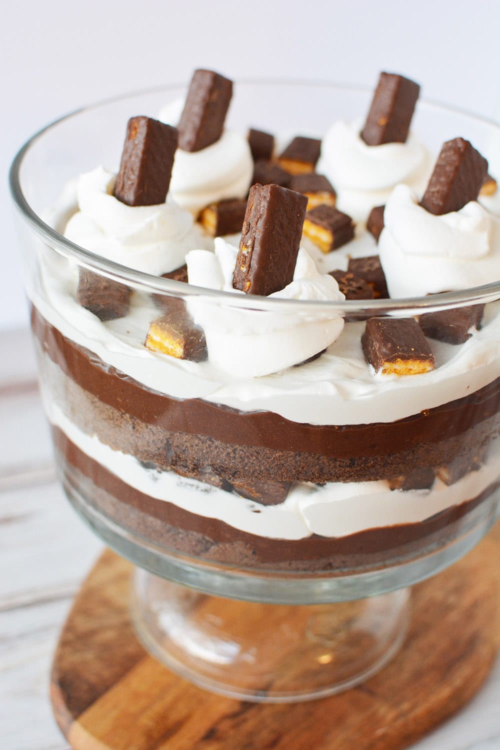 Layers of cake and whipped topping and pudding in a trifle dish.