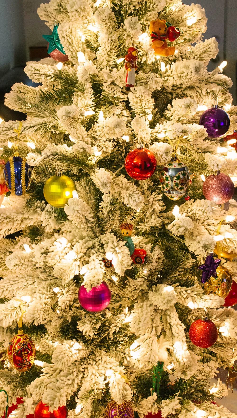 Snow covered christmas tree with ornaments.