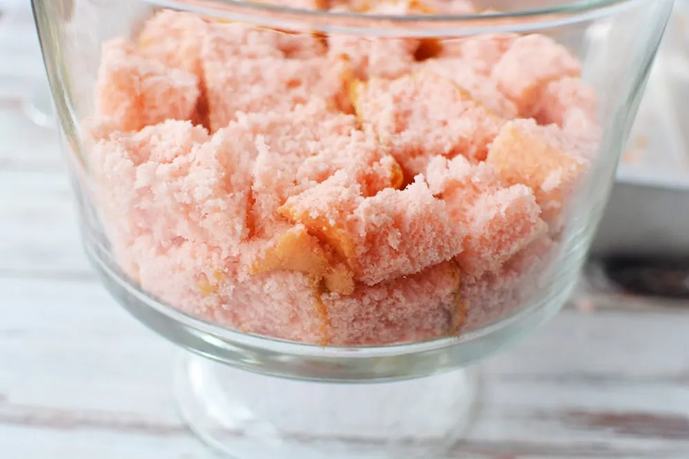 Pieces of strawberry cake in a trifle bowl.