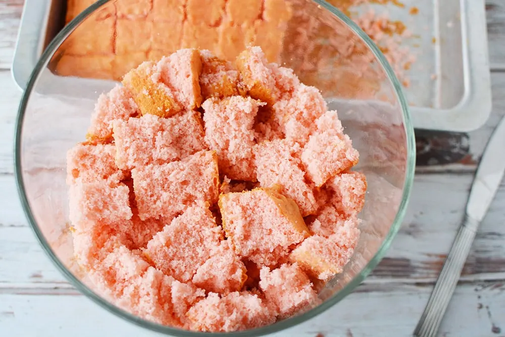 Cubes of strawberry cake in a trifle bowl.