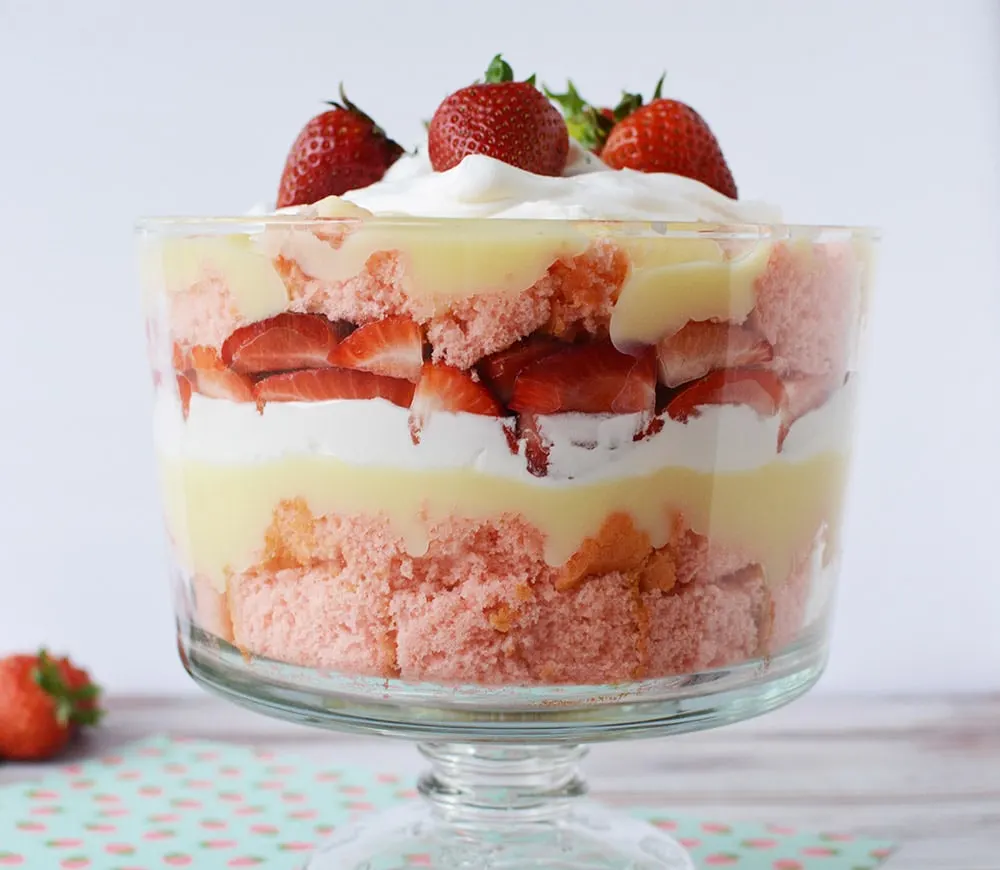 Layered strawberry dessert in a clear trifle bowl. 