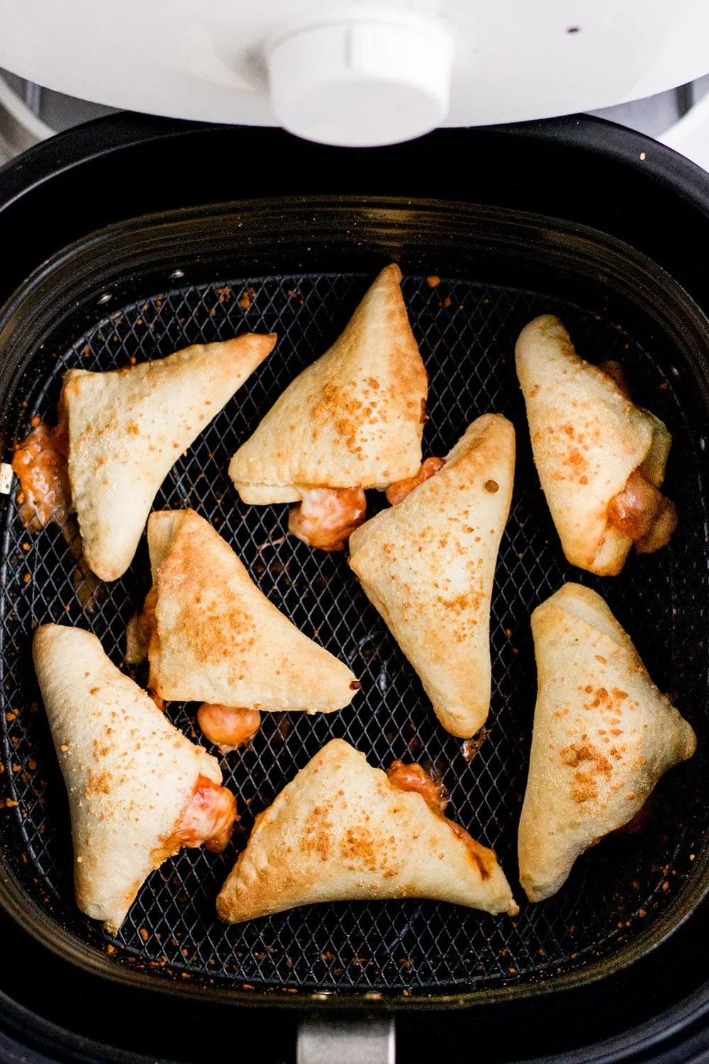 Cooked pizza rolls in an air fryer.