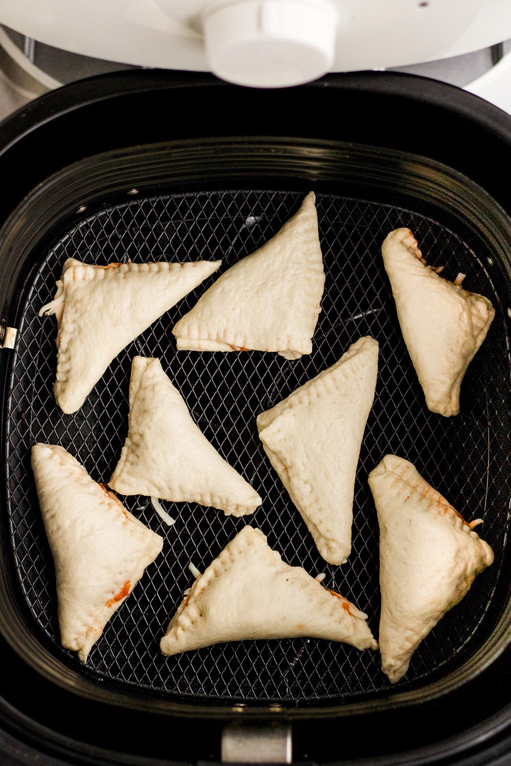 Sealed pizza pockets in an air fryer.