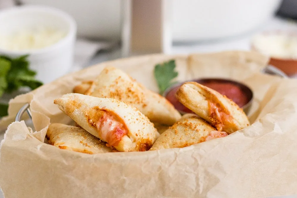 Mini pizza pockets in a basket.