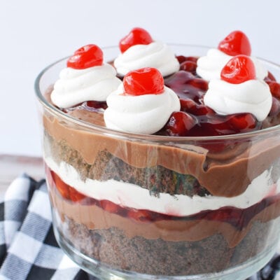 Black forest trifle in a bowl on a table with a checkered napkin.