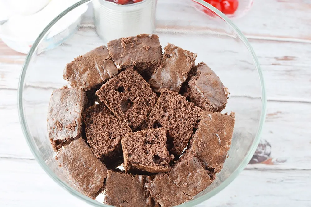 Cubes of chocolate cake in a trifle bowl. 