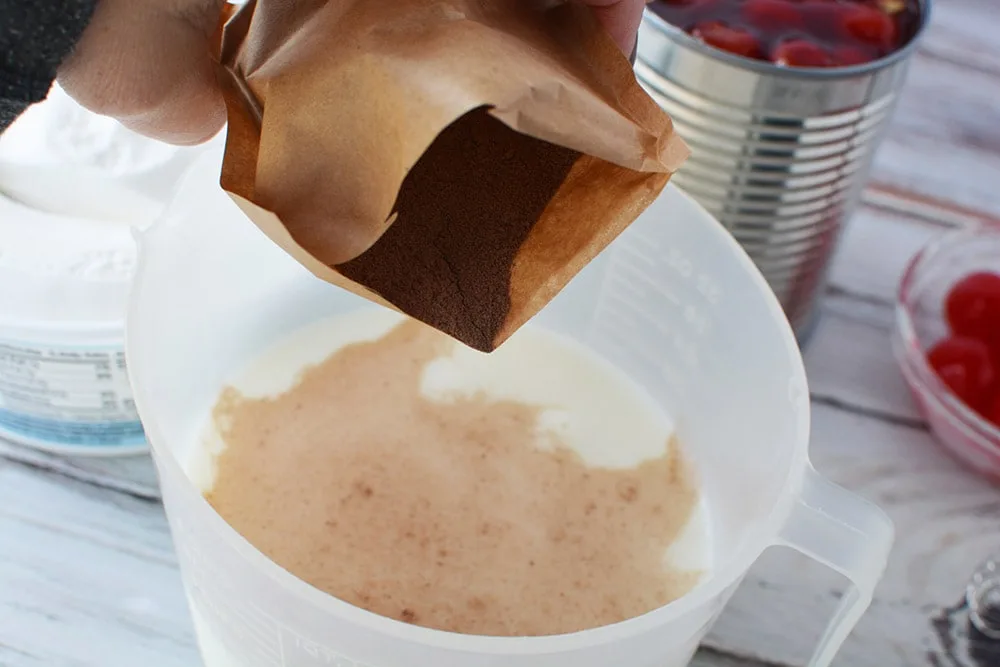 Pudding into milk in a bowl.