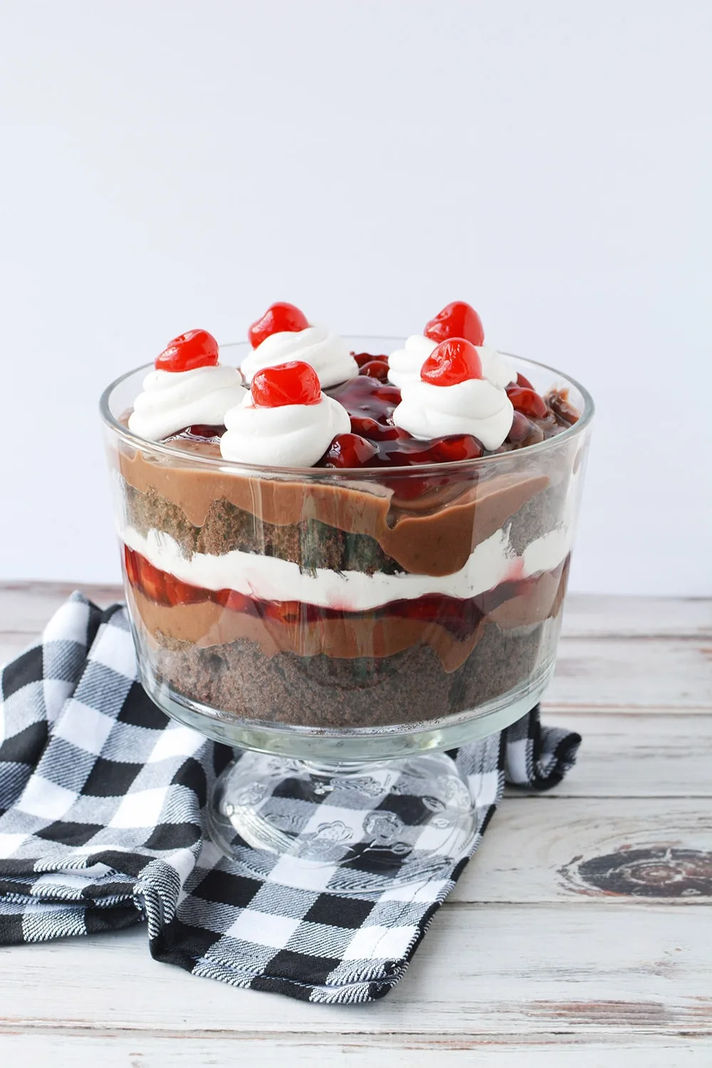 Cherry trifle with layers of chocolate cake, pudding, and whipped cream. 