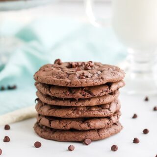 Stack of chocolate chip brownie mix cookies with chips on the table.