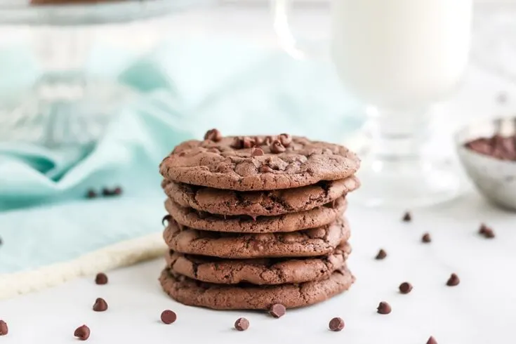 Stack of chocolate chip brownie mix cookies with chips on the table.