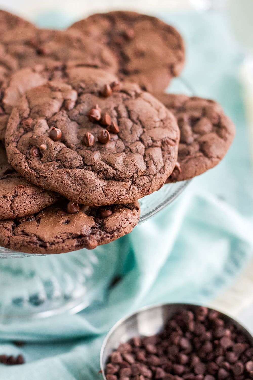 Brownie cookies on a plate by chocolate chips.