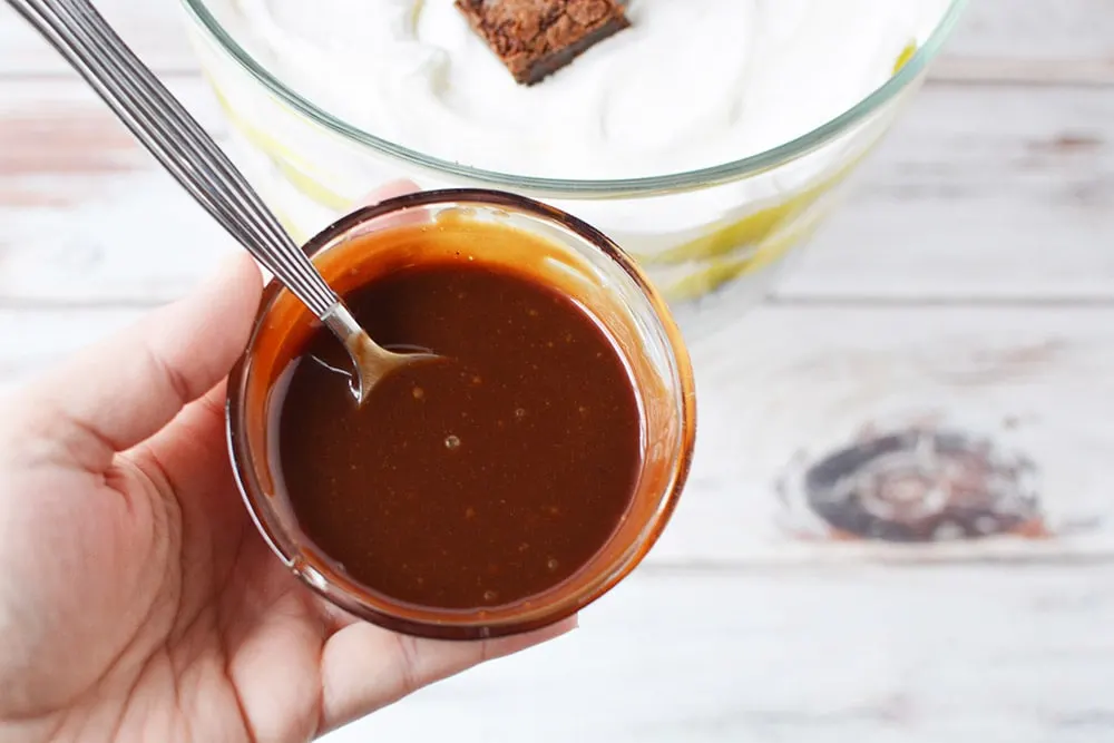 Hot fudge in a bowl with a spoon.