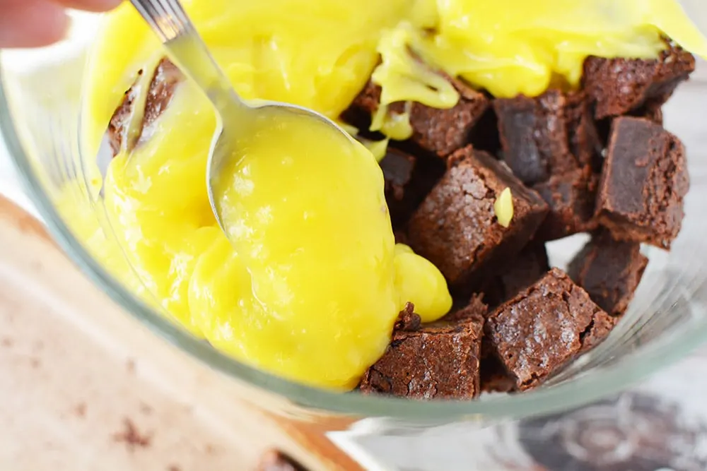 Pudding on top of brownies in a trifle bowl.