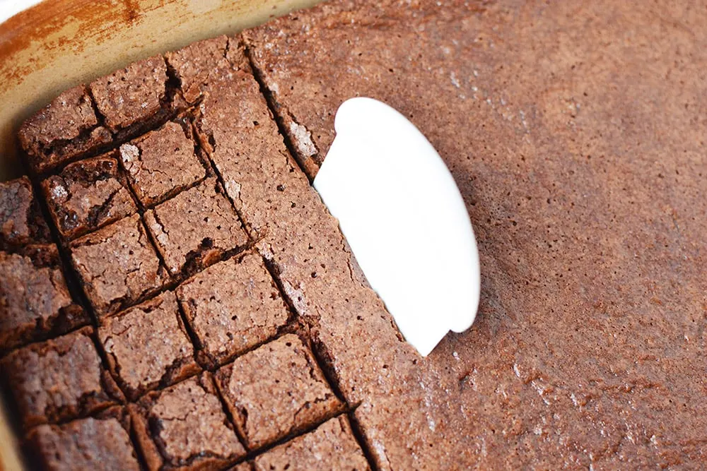 Cutting brownies with a pan scraper.
