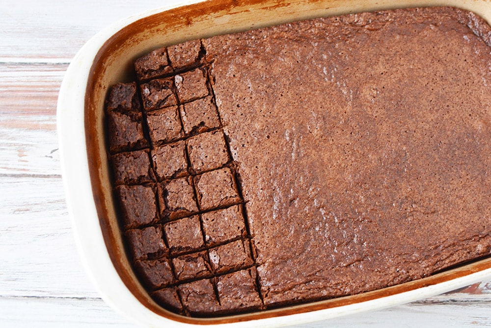 Cutting brownies into squares in a pan.
