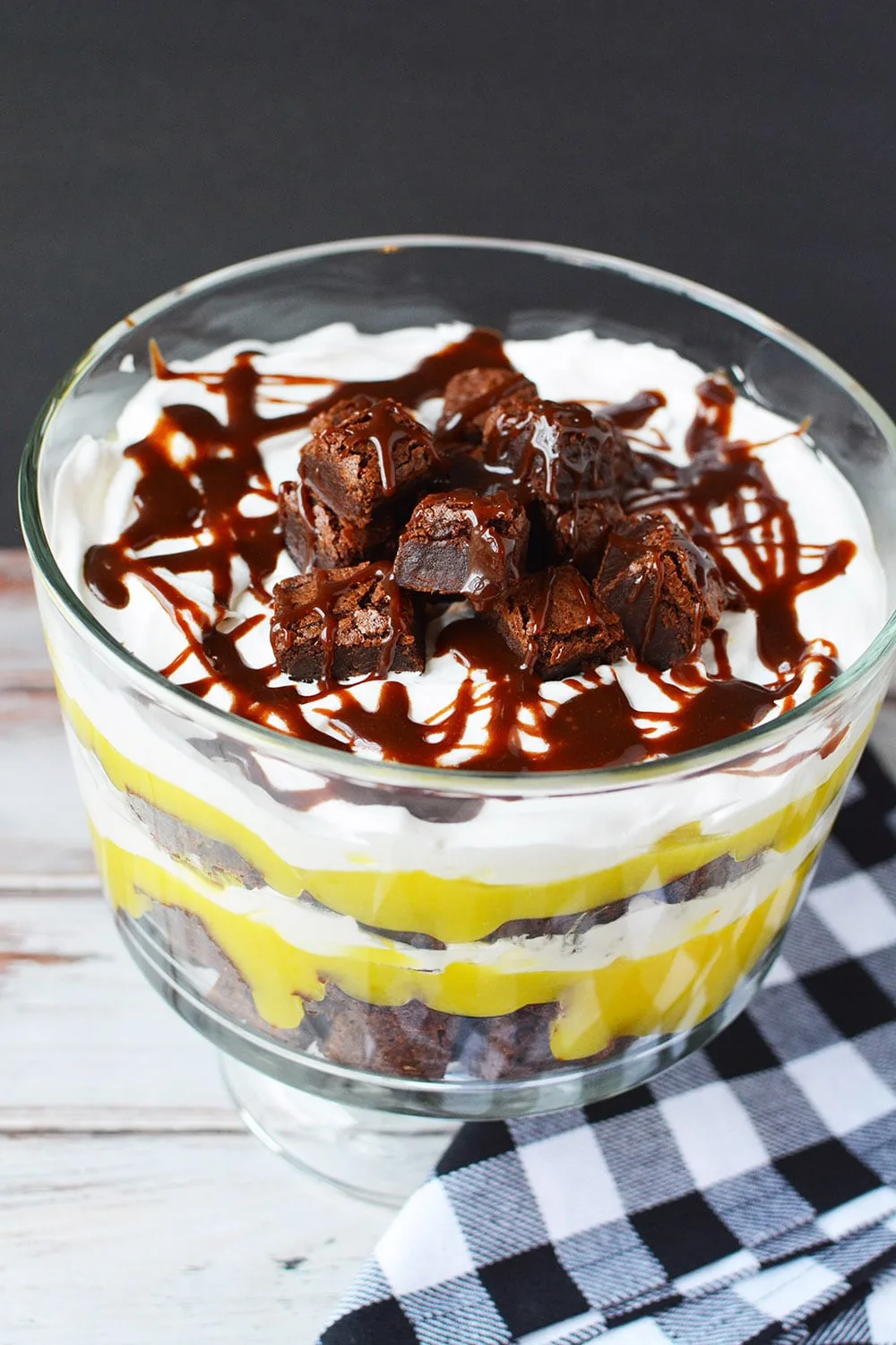 Brownie trifle on a table with a blue checked napkin.