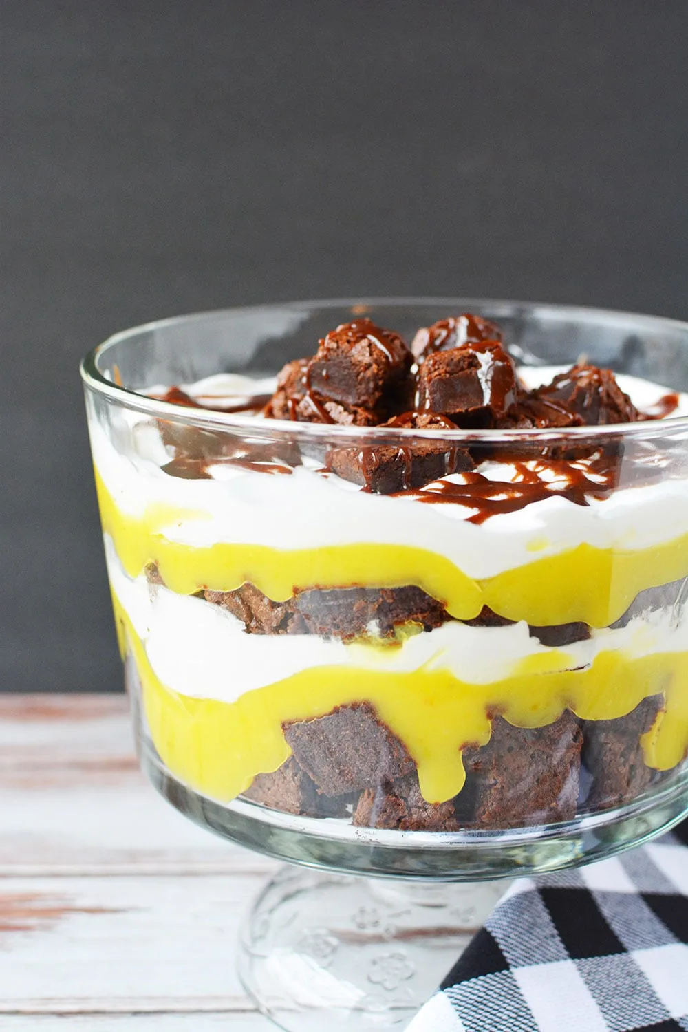 Layers of brownies, pudding, and whipped cream in a trifle dish.