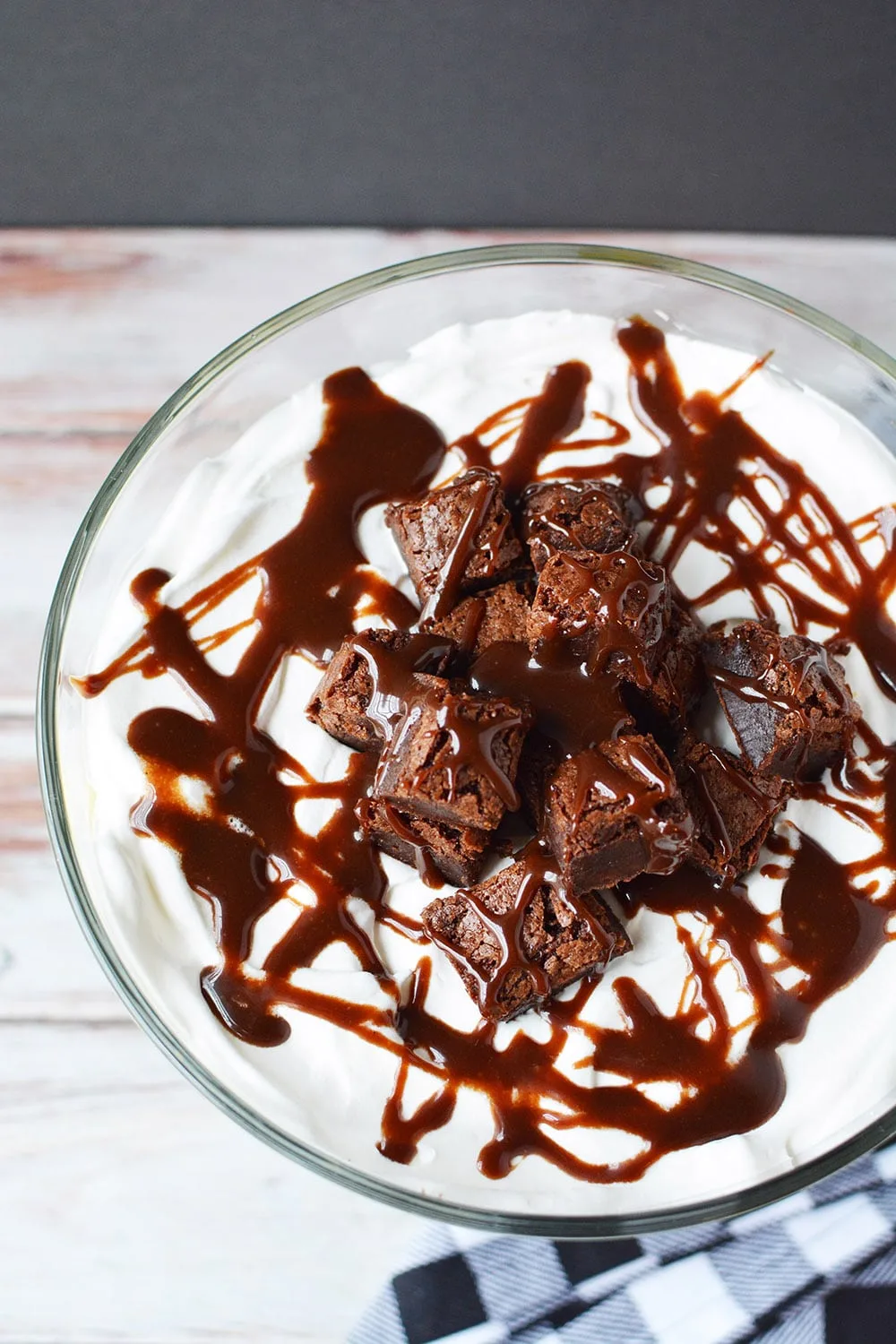 Top of a brownie trifle drizzled with hot fudge.