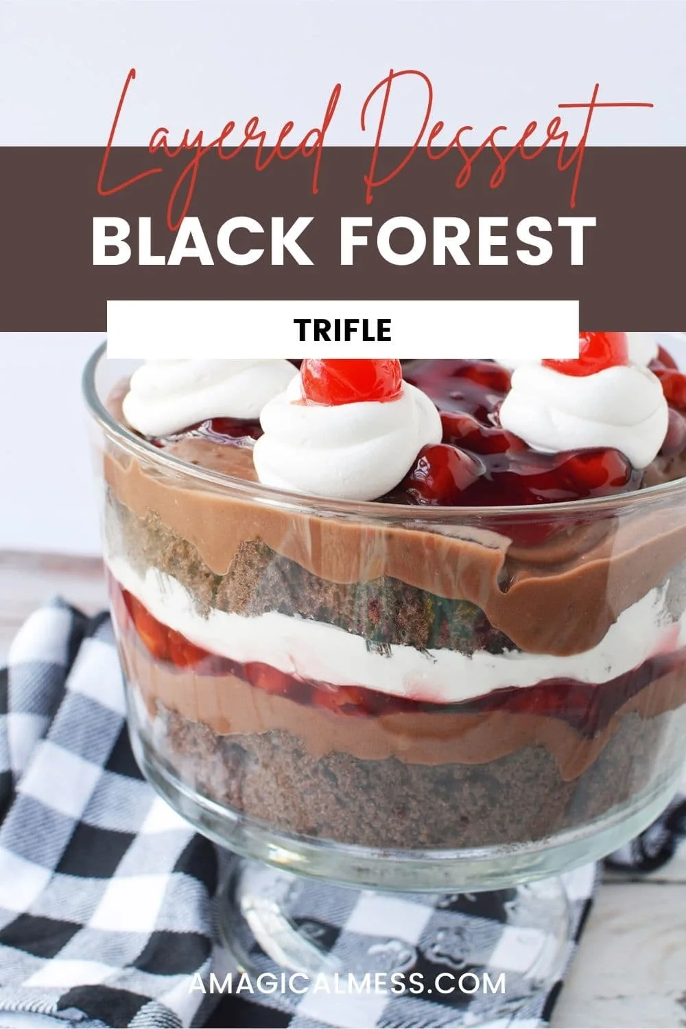 Layers of cake, whipped cream, and cherries in a trifle bowl.
