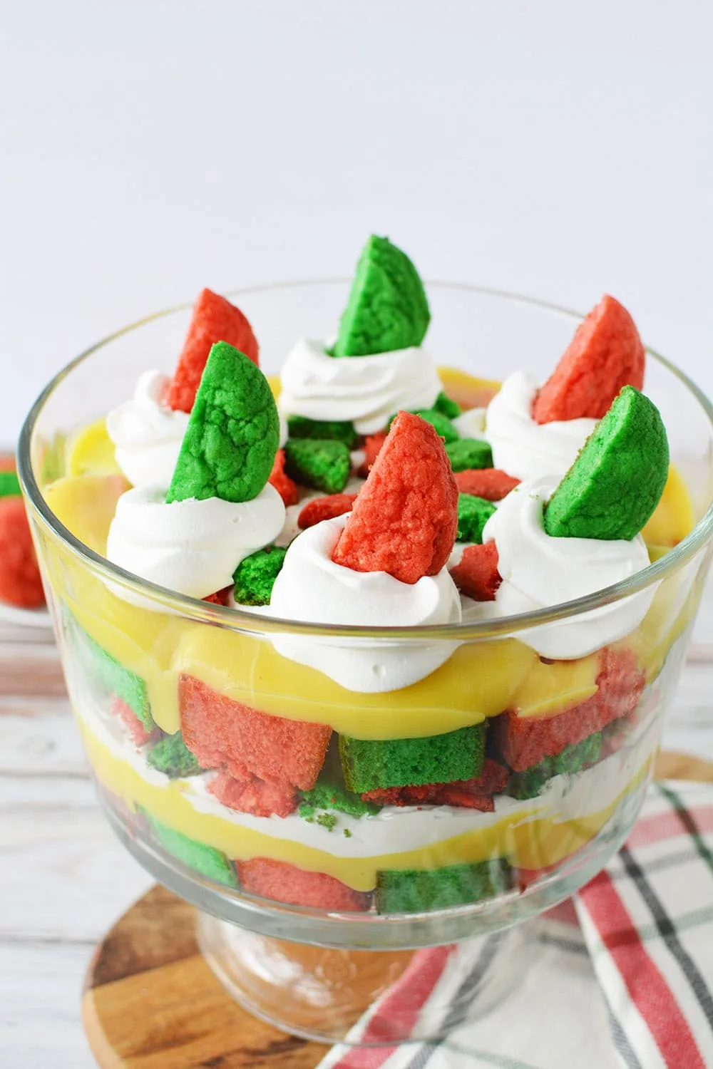Christmas dessert trifle on a table with red and green cake and cookies. 