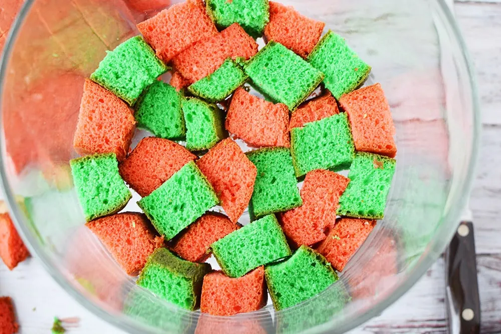 Cubes of red and green cake in a trifle bowl.