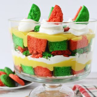 Layers of pudding, green and red cake, cookies, and whipped cream for a Christmas trifle