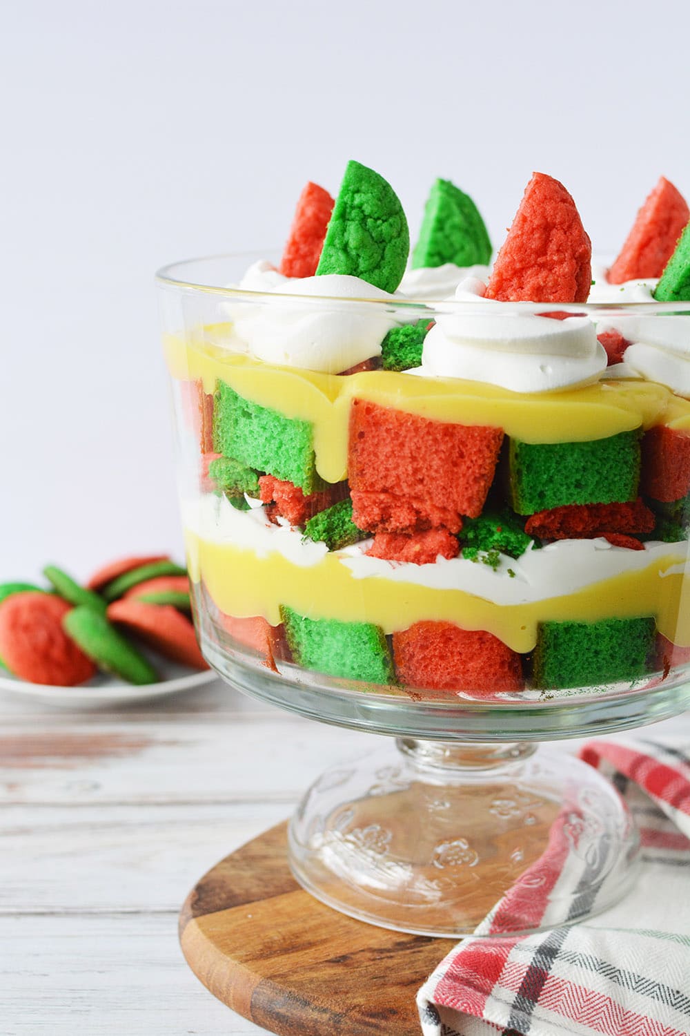 Christmas trifle in a bowl on a table with red and green cookies. 