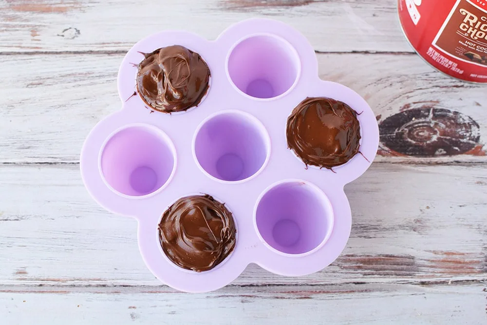 Three hot chocolate bombs in candy mold.