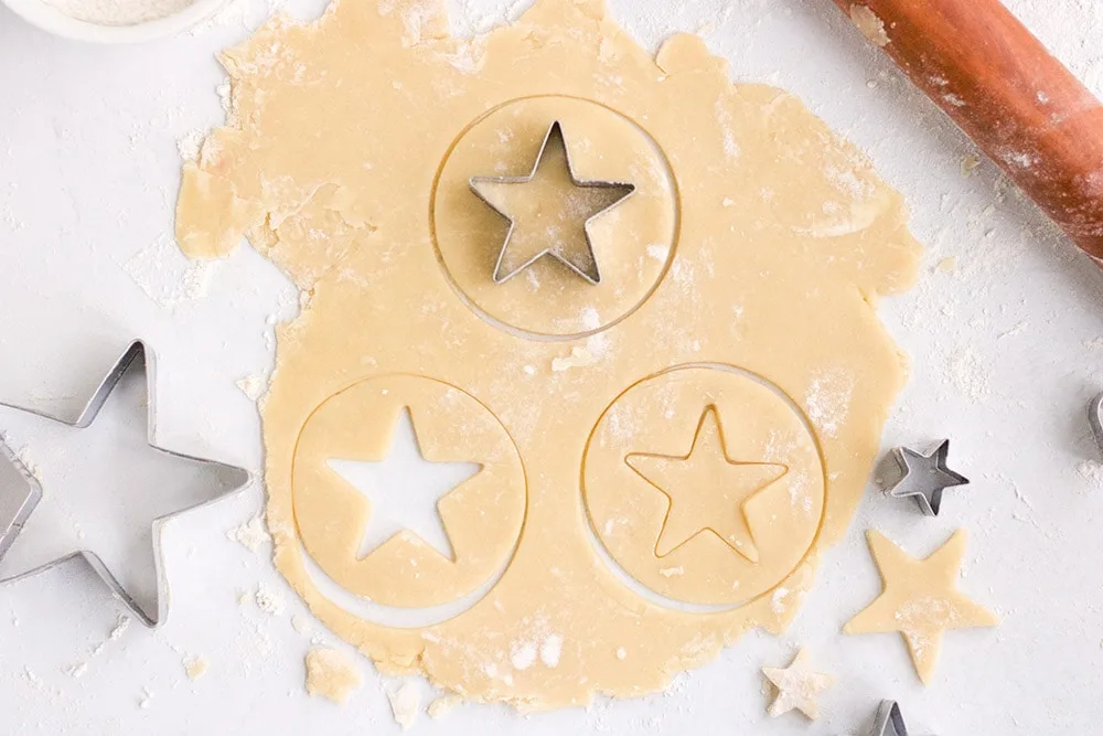 Cutting star shapes into cookie dough. 