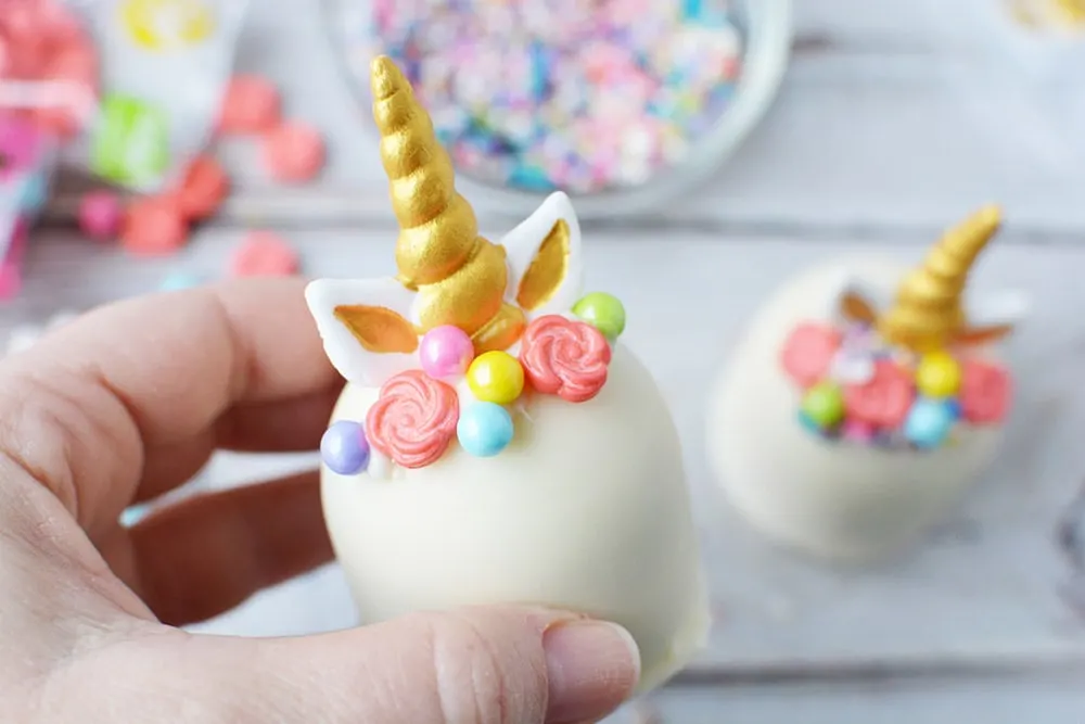 White chocolate unicorn hot chocolate bomb with horn, ears, and mane.