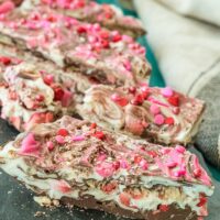 Strawberry crispy bark candy lined up on a board.