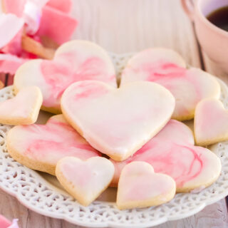 Heart cookies with marble icing with pin decorations on the table.