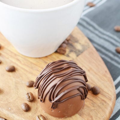 Mocha coffee bomb candy sitting next to a mug full of coffee.