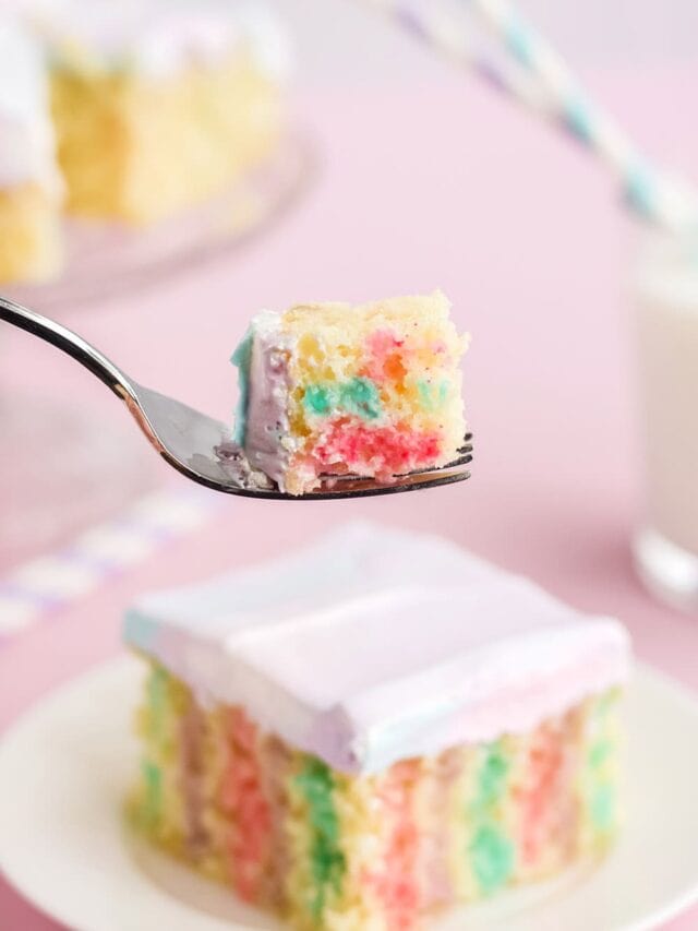 Fork with cake on it in front of a poke cake on a plate.