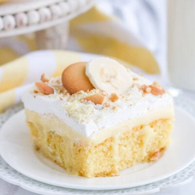 Banana pudding cake topped with whipped cream and cookies.