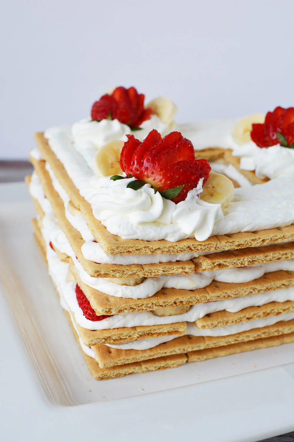 Layers of dessert into an ice box cake with strawberries.