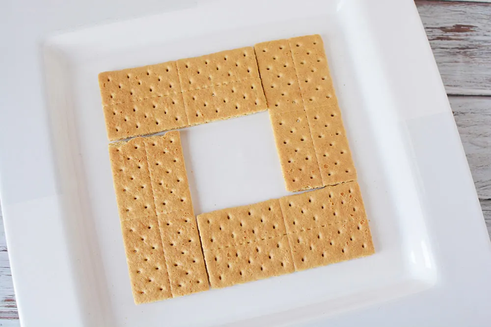 Lining up graham crackers onto a square plate.