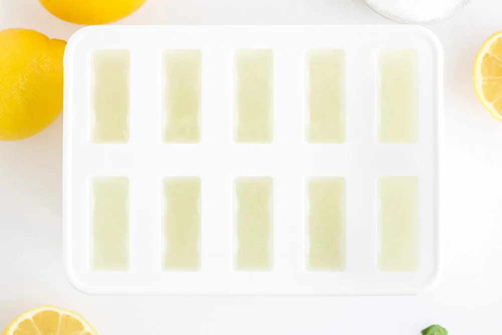 Lemon mixture poured into a white popsicle mold.