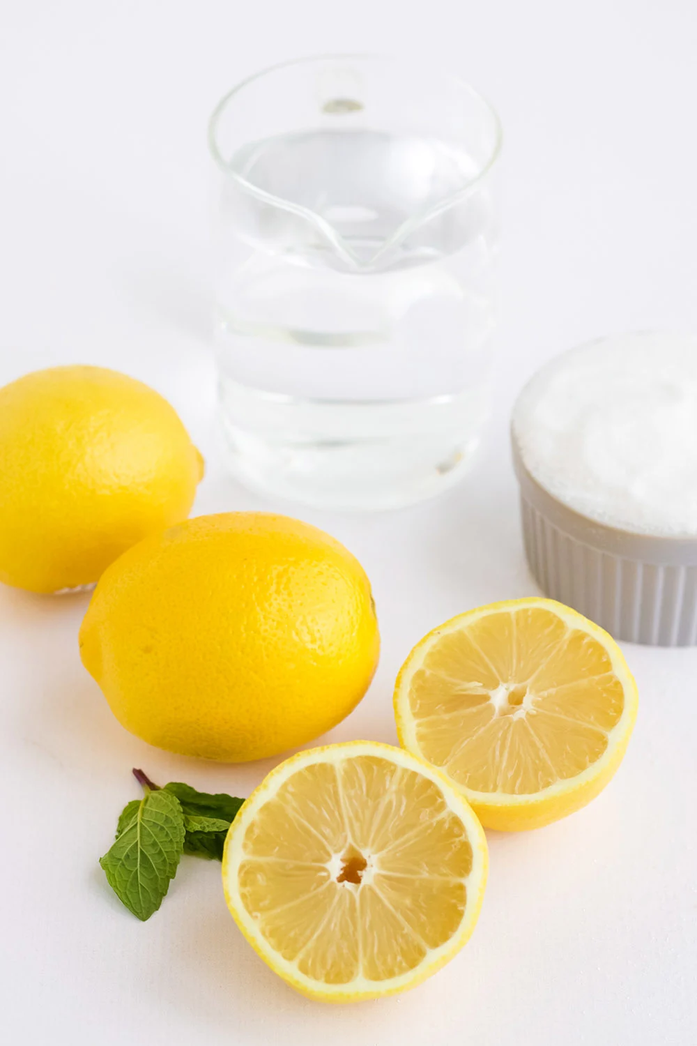 Water, lemons, and sugar on a table.